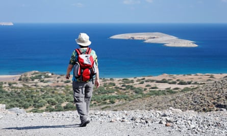 A hiker on a sunny Greek island, blue sea visible in the background