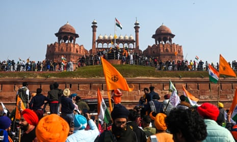 Farmers stand on the ramparts of Red Fort as they continue to protest against new agricultural laws.