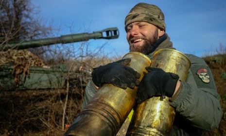 A Ukrainian artilleryman carries empty cartridges from 152 mm 2S3 Akatsiya (self-propelled howitzer) in a field near an undisclosed frontline position in eastern Ukraine yesterday.