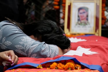 Rachana Khatiwada leans on a coffin containing the remains of her son