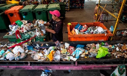 A worker gathers plastic waste at a trash bank in Surabaya, Indonesia’s second largest city.