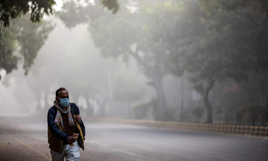 A man walks along a street amid smoggy conditions in Delhi.
