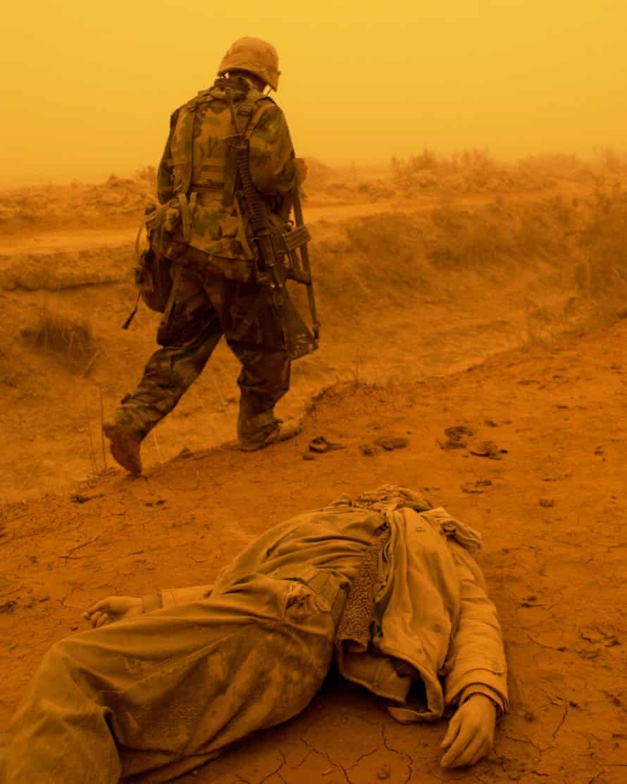 A US marine passes the corpse of an Iraqi soldier killed during a failed ambush on US forces marching to Baghdad