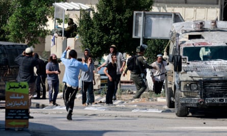 Des soldats israéliens sur une position près de la ville de Deir Sharaf alors que des colons juifs se rassemblent, dans le gouvernorat de Naplouse, en Cisjordanie occupée, le 2 novembre 2023.
