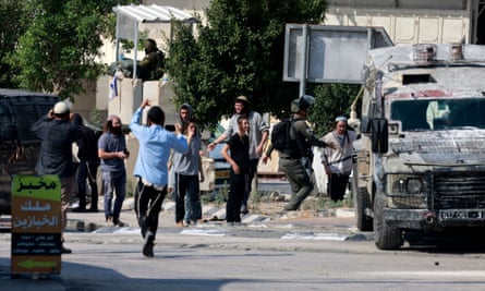 Israeli soldiers at a position near the town of Deir Sharaf as Jewish settlers gather, in the Nablus governorate of the occupied West Bank, on 2 November 2023.