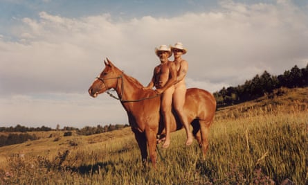 Two members of a gay rodeo group ride a horse
