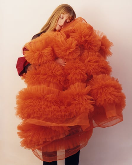 Clutching a large, red fluffy  dress
