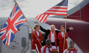 Richard Branson, centre, with two members of the Virgin Atlantic flight crew, with UK and US flags, in 2014