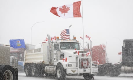 Anti-COVID-19 vaccine mandate demonstrators gather as a truck convoy blocks the highway at the busy U.S. border crossing in Coutts, Alberta, Canada, Monday, Jan. 31, 2022. (Jeff McIntosh/The Canadian Press via AP)