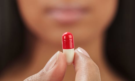 Close up of mixed race woman holding medication capsule