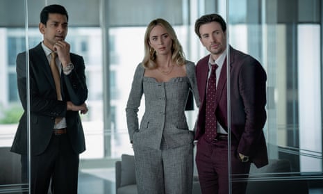 Emily Blunt, centre, with Amit Shah and Chris Evans in Pain Hustlers in an office setting