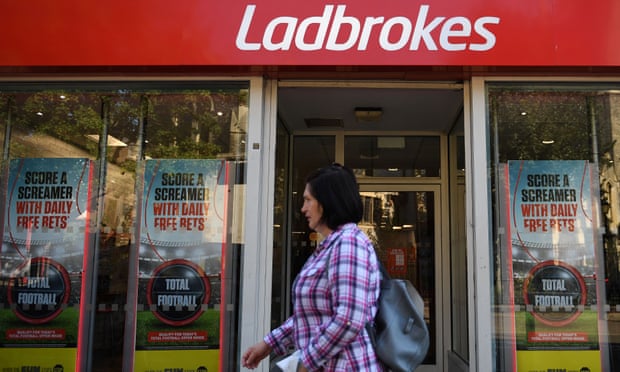A pedestrian walks past a Ladbrokes betting shop in east London