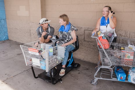 David Hondula talks with two women waiting for transportation outside a store about cooling shelters nearby.