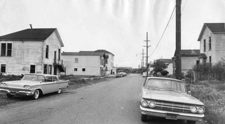 Cars parked on a street in an old black-and-white photo.