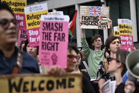Protesters hold up banners with message reading ‘Smash the Far Right’ and ‘Welcome’