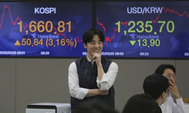 A currency trader smiles at the foreign exchange dealing room of the KEB Hana Bank headquarters in Seoul, South Korea