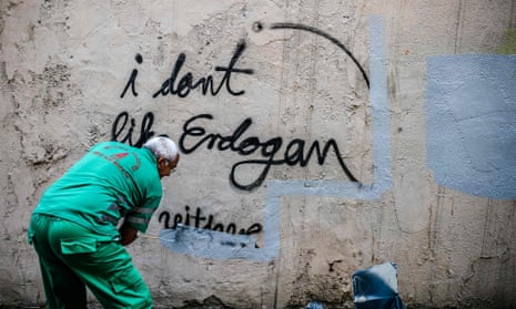 A municipal worker covers graffiti near the pro-Kurdish Özgür Gündem newspaper’s Istanbul headquarters in June