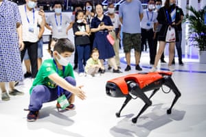Nanjing, China: A child interacts with an Alpha Dog walking robot during the 16th China (Nanjing) International Software Product and Information Service trade fair