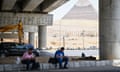 People sit in the shade in front of Pyramid of Giza, Egypt on 8 June 2024