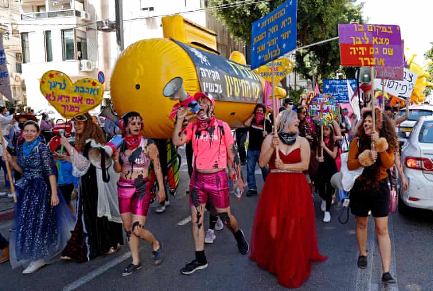 Israelis wearing costumes take part in a parade during the festivities of the Jewish Purim holiday on 26 February, 2021 in Tel Aviv. Israel imposed a night-time curfew for three nights from yesterday evening to curb the spread of coronavirus from 8:30 pm to 5:00 am.