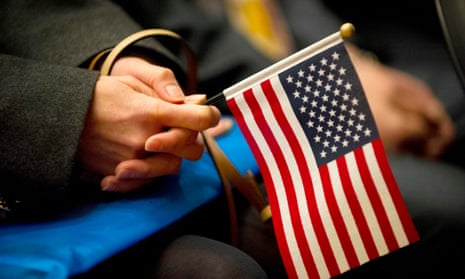 A woman holds a US Flag during a naturalization ceremony in Lowell, Massachusetts, this month.
