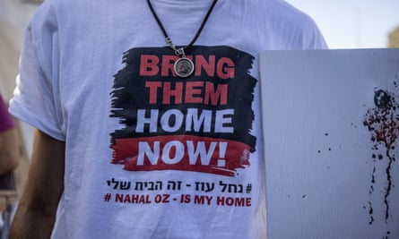 A man holds a placard as relatives of hostages held by Hamas and those who lost their lives on 7 October set up tents in front of Knesset on 8 November.