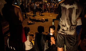 Residents surround the body of an alleged drug user killed in Manila.