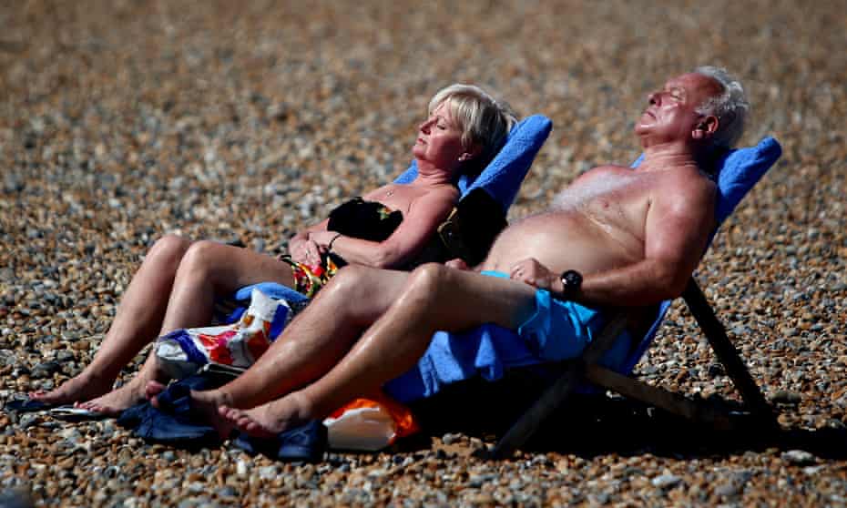 A couple sunbathe in Brighton.