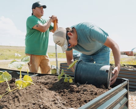 Two men planting in a raised bed.