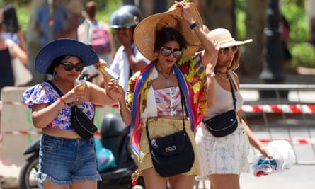Women walk near Mondello beach during a heatwave in Palermo.