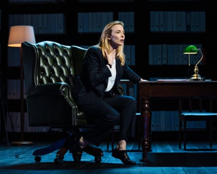 Jodie Comer sitting on a large chair next to a table