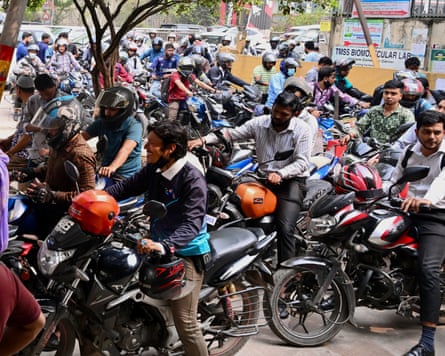 People queue up to refuel their motorbikes at a gas station in Dhaka, Bangladesh