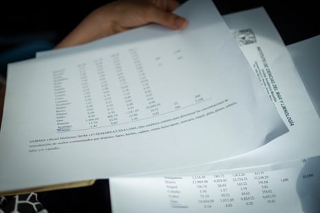 A hand holds papers with columns of numbers.