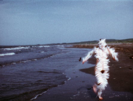 A woman running along the beach covered in feathers
