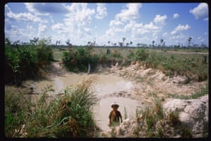 A small Vietnamese child stands in a pool of muddy water on an area of open land defoliated during the war, in Tay Ninh, Vietnam, 1985