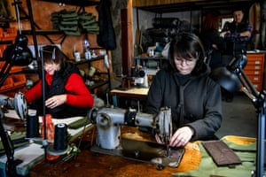 A woman works to make steel vests for Ukrainian soldiers using scrap metals from cars