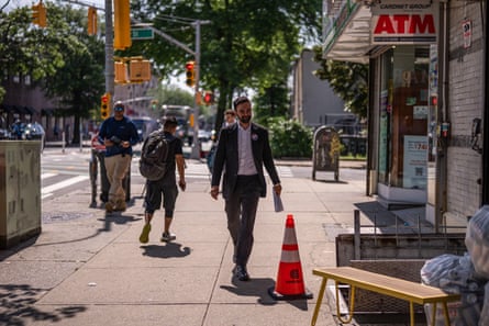 a man in a suit walks on a sidewalk