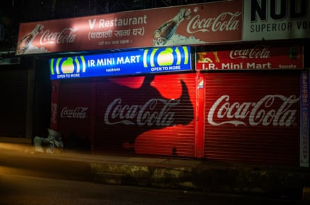 A shadow of a rhino on a closed shop shutter with a Coca Cola sign painted on it