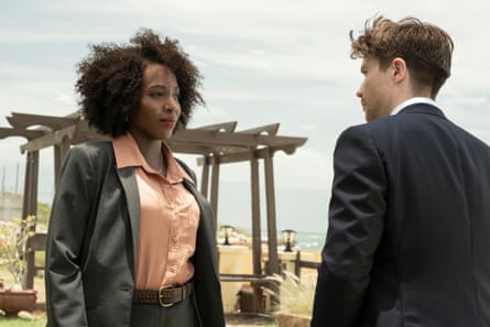 A black woman in a smart blouse and overcoat is looking at a white man in a suit