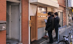 Two men in suits looking at menu outside Kuroki Shop