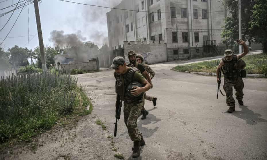 I militari ucraini corrono ai ripari durante un duello di artiglieria tra le truppe ucraine e russe a Lysychansk, nel Donbas.