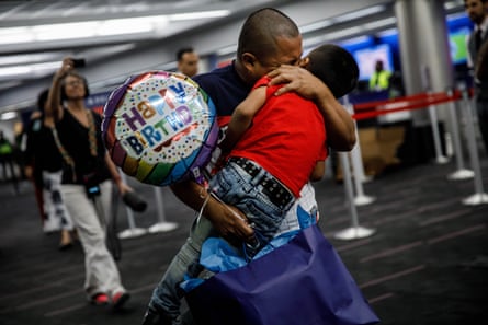 A man and a young boy embrace.