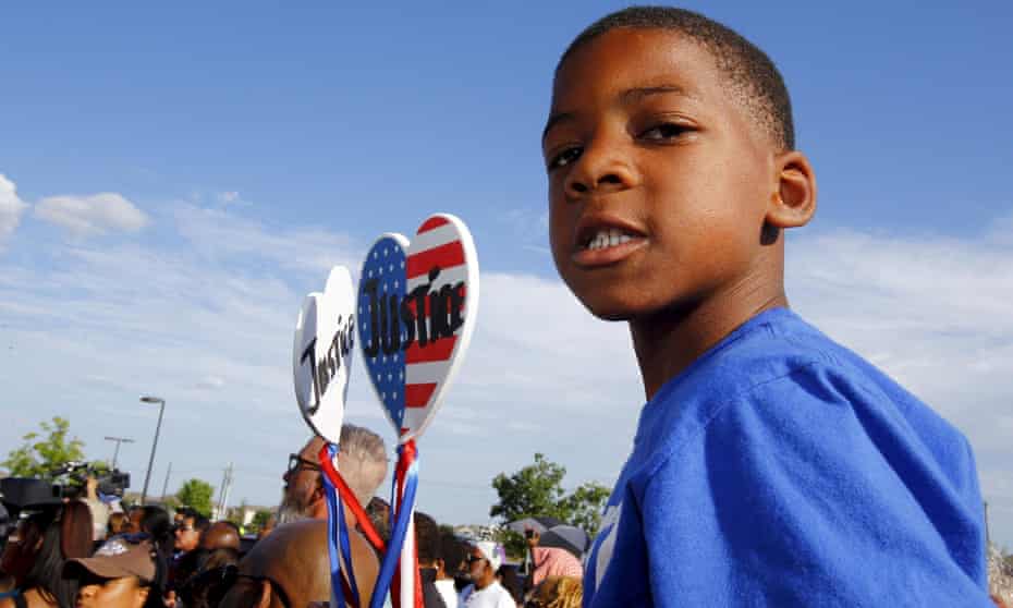Aarington Traylor holds signs calling for justice during a protest against police behaviour in McKinney, Texas.
