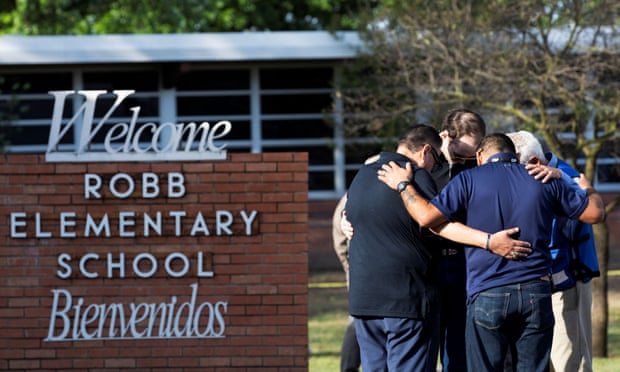 People standing outside Robb elementary school in Uvalde, Texas, 25 May 2022.