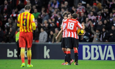 Andoni Iraola celebrates a victory with teammates Carlos Gurpegui and Ander Iturraspe as Gerard Pique walks off after La Liga match between Athletic Bilbao and Barcelona at the San Mamés Stadium on 1 December 2013