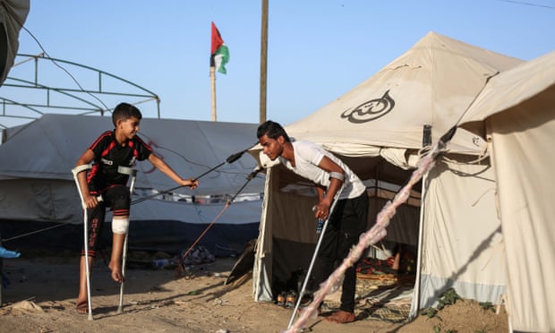 Palestinians on crutches at al-Bureij refugee camp on 17 May.