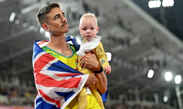 Brandon Starc spends a few moments with his baby after winning the silver medal in the high jump.