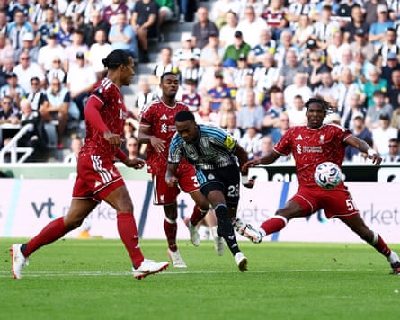 Joe Willock scores a goal despite the attentions of several Liverpool players