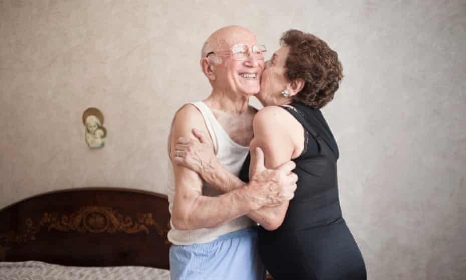 Happy older couple hugging in a bedroom