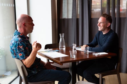 Andrew and Oliver sit at a restaurant table, chatting